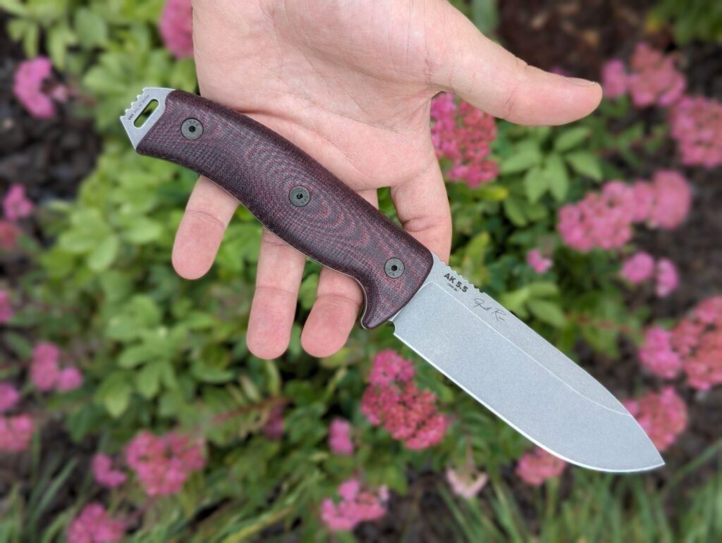 someone holding an AK 5.5 knife with brown handle