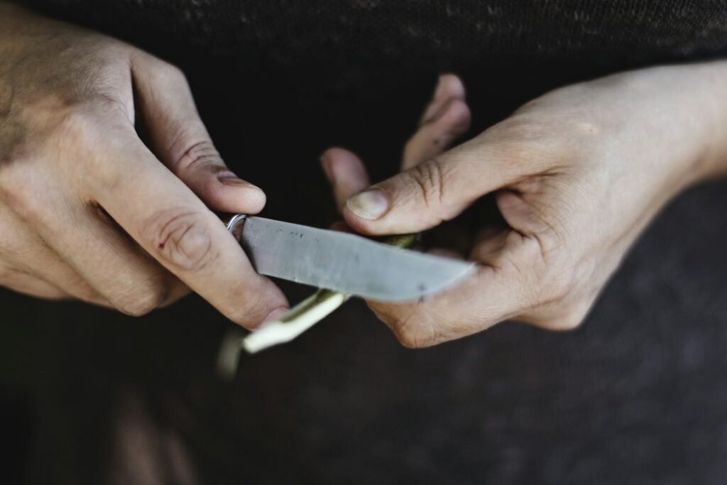 Person holding a knife and sharpening its blade