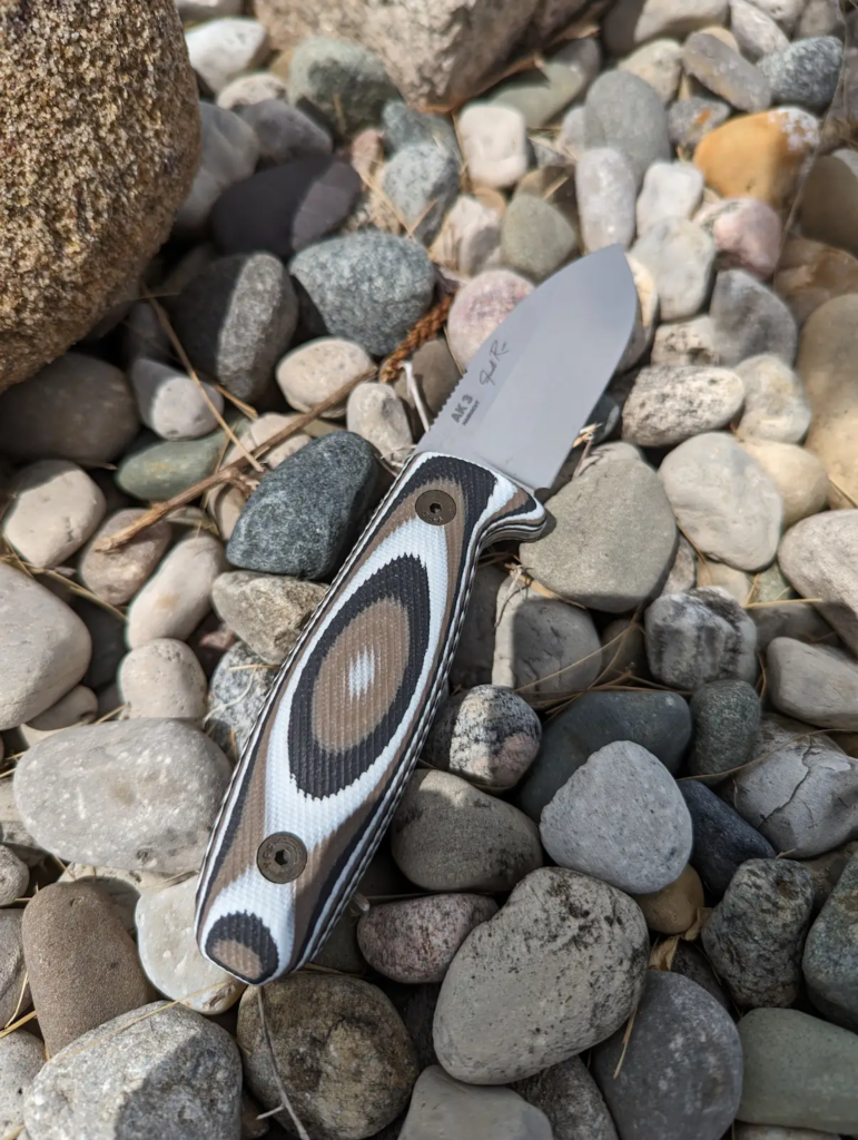 a knife with a white, black, and brown handle